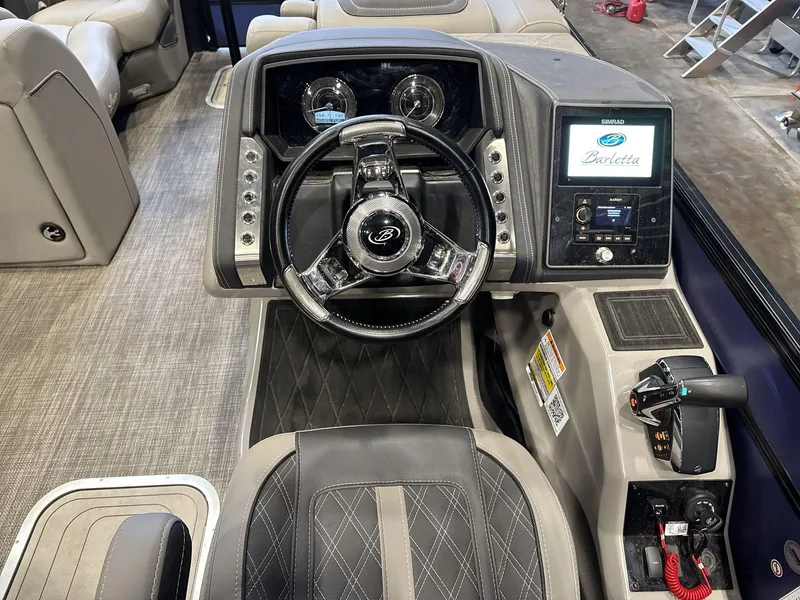Slide: The Image of 2023 Barletta Lusso 25MA boat dashboard with steering wheel and control panel. - 11