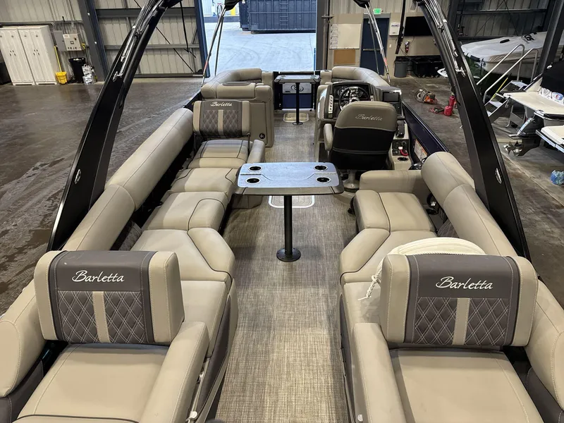 Slide: The Image of 2023 Barletta Lusso 25MA luxury pontoon boat interior with plush seating and table. - 7
