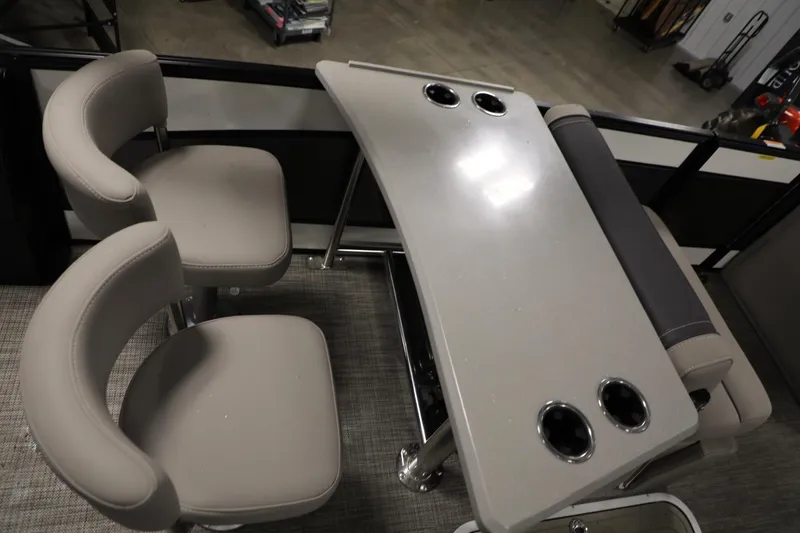 Slide: The Image of 2023 Barletta L25UEA boat interior with seating and table featuring cup holders. - 20