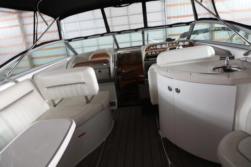 Slide: The Image of Interior of a 2006 Cobalt 323 boat with white seating and a compact kitchenette. - 10