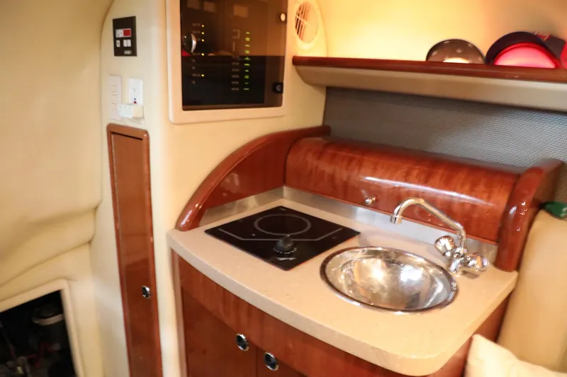 Slide: The Image of Compact kitchen area in a 2006 Cobalt 323 boat with sink and stove. - 12