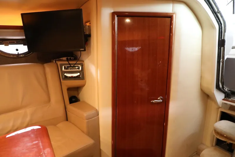 Slide: The Image of Interior of a 2006 Cobalt 323 boat with TV, leather seating, and wooden door. - 13