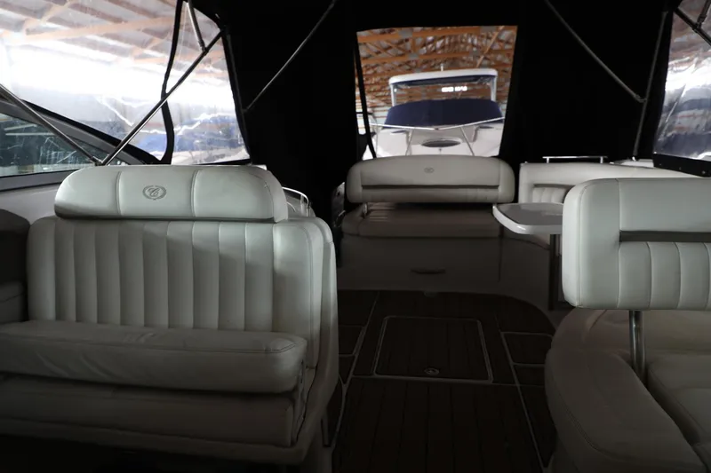 Slide: The Image of Interior of a 2006 Cobalt 323 boat with white leather seating and wooden flooring. - 15
