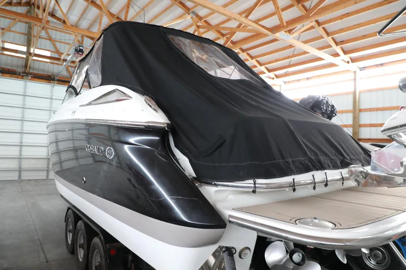 Slide: The Image of 2006 Cobalt 323 boat with black cover in storage facility. - 3