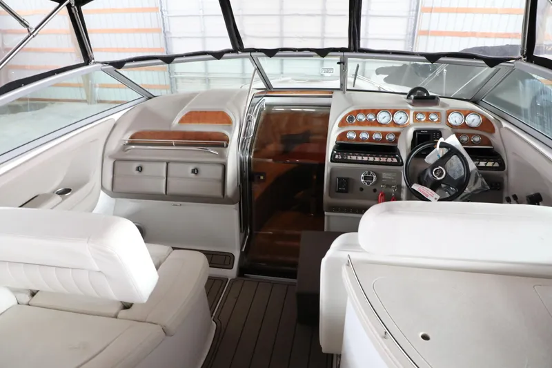 Slide: The Image of Interior of a 2006 Cobalt 323 boat with white seating and a detailed dashboard. - 5