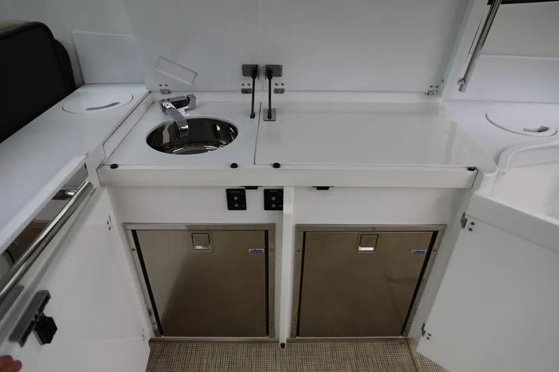 Slide: The Image of 2016 Cobalt A40 boat kitchen area with sink, storage cabinets, and countertop. - 10