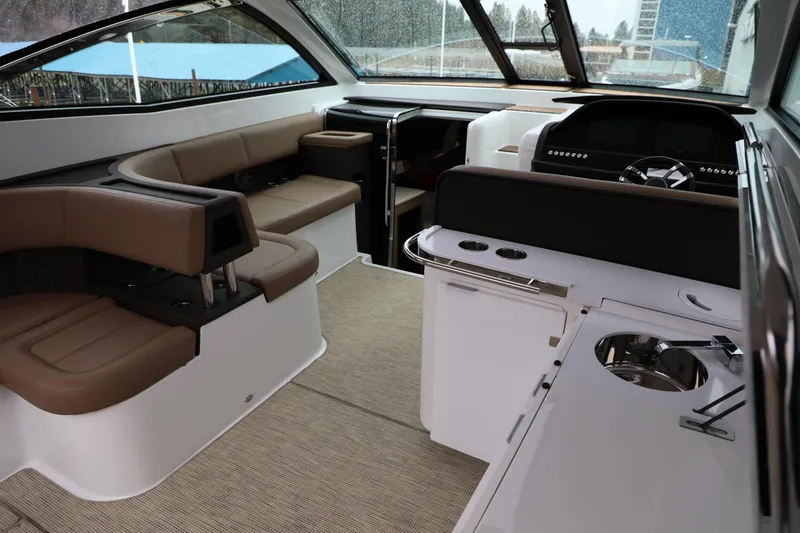 Slide: The Image of Interior of a 2016 Cobalt A40 boat with seating, kitchenette, and steering area. - 8