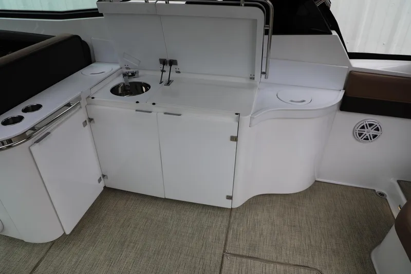 Slide: The Image of Interior of 2016 Cobalt A40 boat featuring a compact kitchenette with sink and storage. - 9
