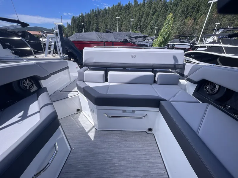 Slide: The Image of 2024 Cobalt R4 boat interior with sleek seating and modern design, docked near forested area. - 15