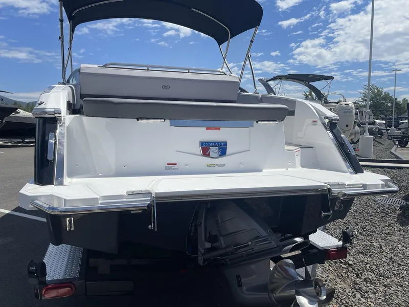 Slide: The Image of 2024 Cobalt R4 boat rear view with swim platform and canopy under blue sky. - 6