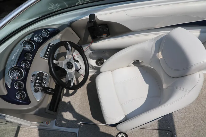 Slide: The Image of 2010 Crownline 220 LS boat cockpit with steering wheel and white captain's chair. - 11