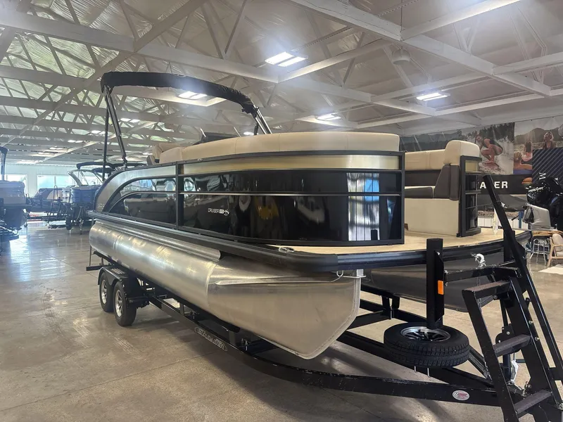 Slide: The Image of 2024 Harris Cruiser 210 pontoon boat displayed indoors on a trailer. - 4
