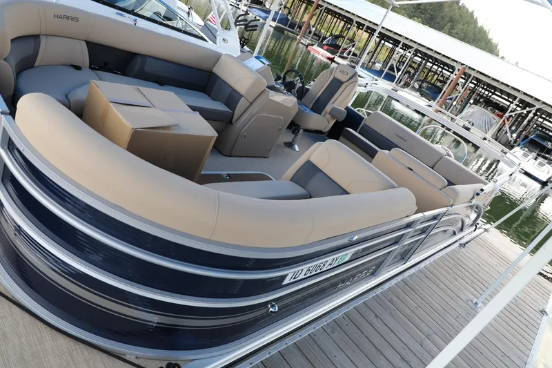 Slide: The Image of 2023 Harris Cruiser 230 pontoon boat docked with beige seating and cardboard boxes. - 7