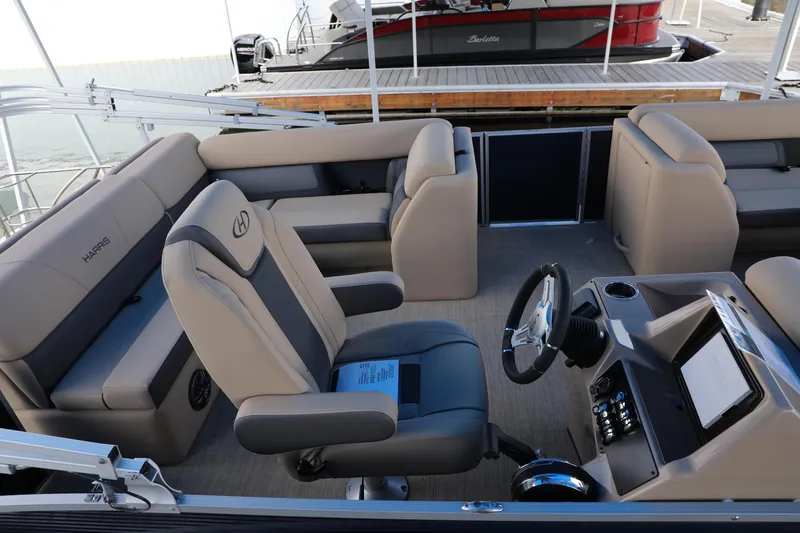 Slide: The Image of 2023 Harris Cruiser 230 boat interior with plush seating and modern steering console. - 8
