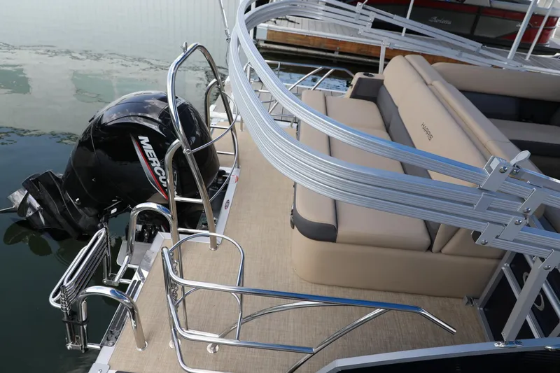 Slide: The Image of 2023 Harris Cruiser 230 pontoon boat with Mercury engine and beige seating. - 9