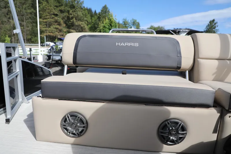 Slide: The Image of 2024 Harris Cruiser 230 boat seating with integrated speakers, set against a scenic outdoor backdrop. - 11