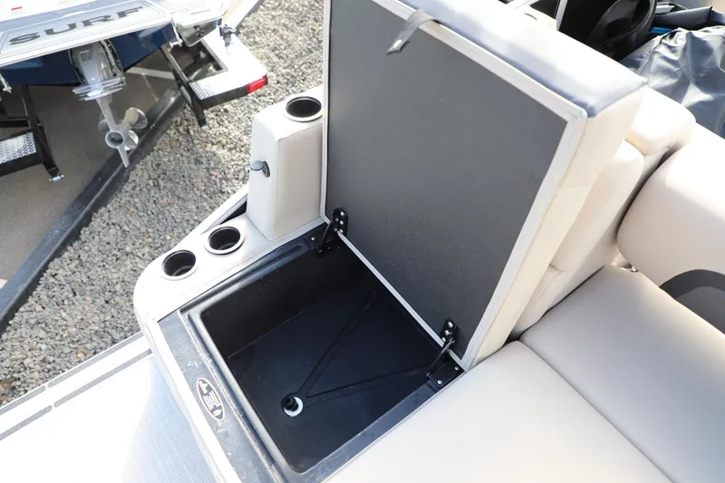 Slide: The Image of Open storage compartment on 2024 Harris Cruiser 230 boat with cup holders. - 13