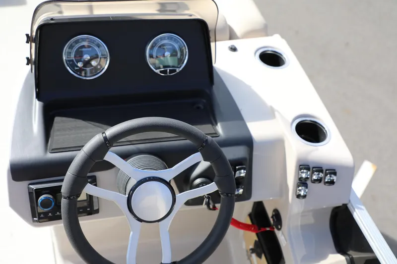 Slide: The Image of 2024 Harris Cruiser 230 boat dashboard with steering wheel and gauges. - 15