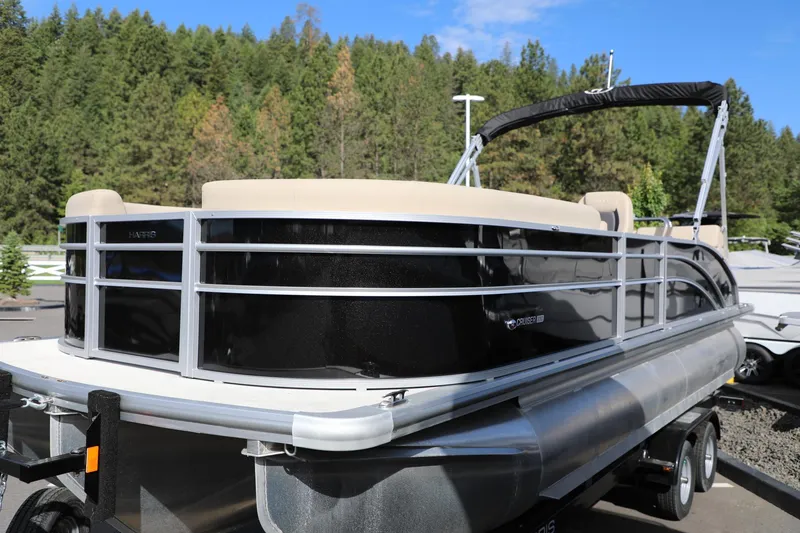 Slide: The Image of 2024 Harris Cruiser 230 pontoon boat with sleek design, parked outdoors. - 4