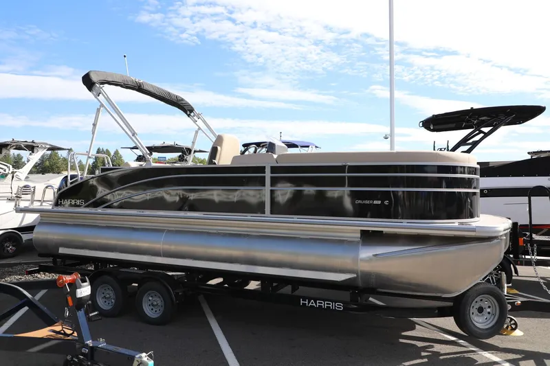 Slide: The Image of 2024 Harris Cruiser 230 pontoon boat on trailer under clear sky. - 5