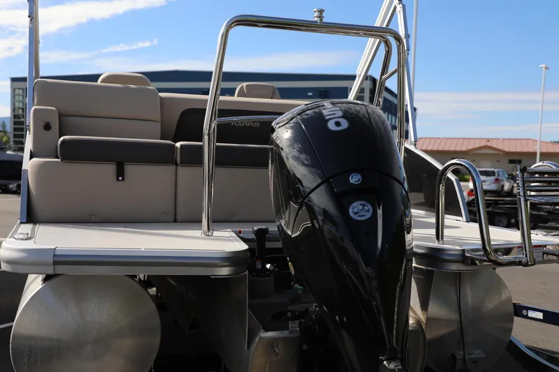 Slide: The Image of 2024 Harris Cruiser 230 pontoon boat with outboard motor, docked under clear skies. - 7