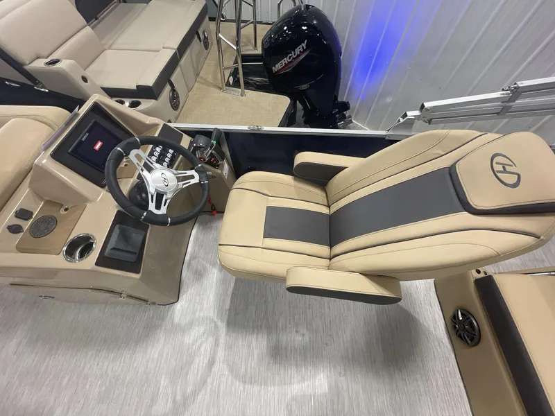Slide: The Image of 2023 Harris Cruiser 250 boat interior with steering wheel and comfortable seating. - 10