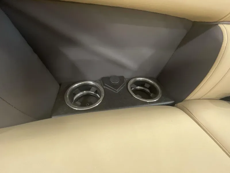 Slide: The Image of 2023 Harris Cruiser 250 interior cup holders with beige and black seating. - 14
