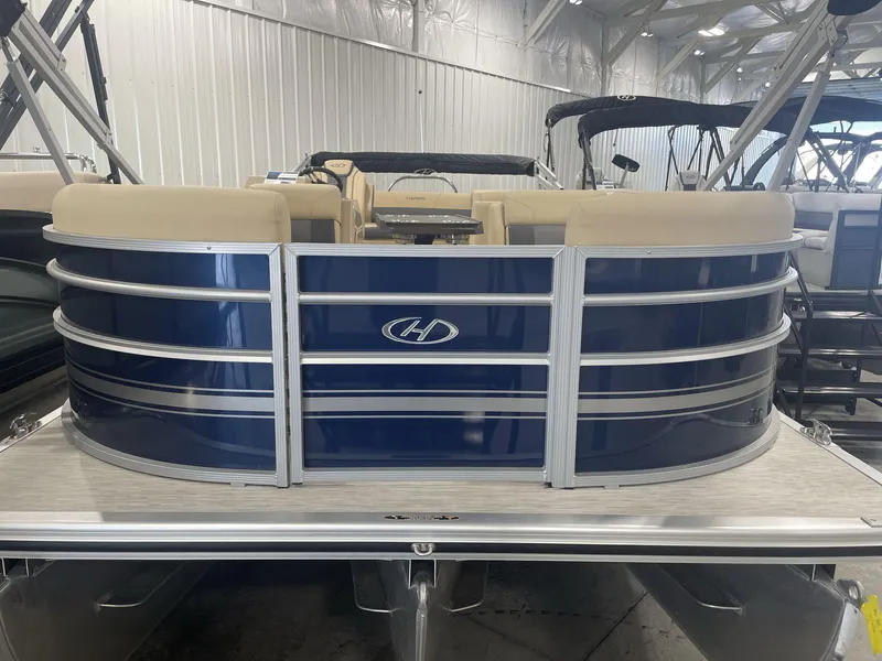 Slide: The Image of 2023 Harris Cruiser 250 pontoon boat in showroom, featuring blue exterior and beige seating. - 3