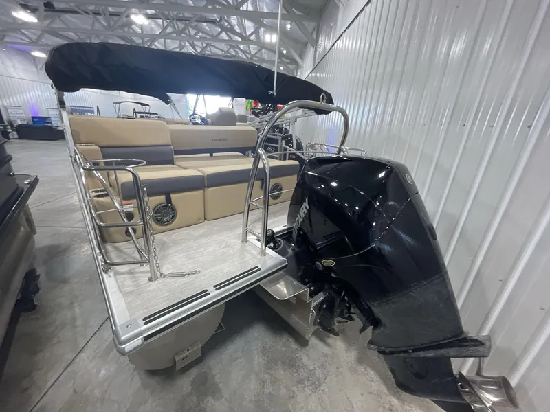 Slide: The Image of 2023 Harris Cruiser 250 pontoon boat with Mercury outboard motor in a showroom. - 5