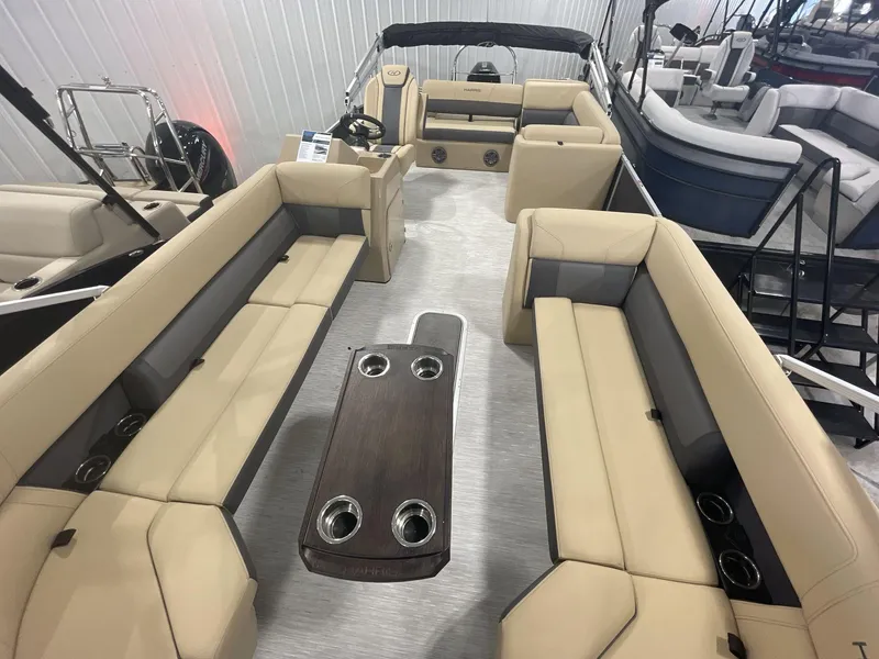 Slide: The Image of 2023 Harris Cruiser 250 pontoon boat interior with beige seating and central table. - 6