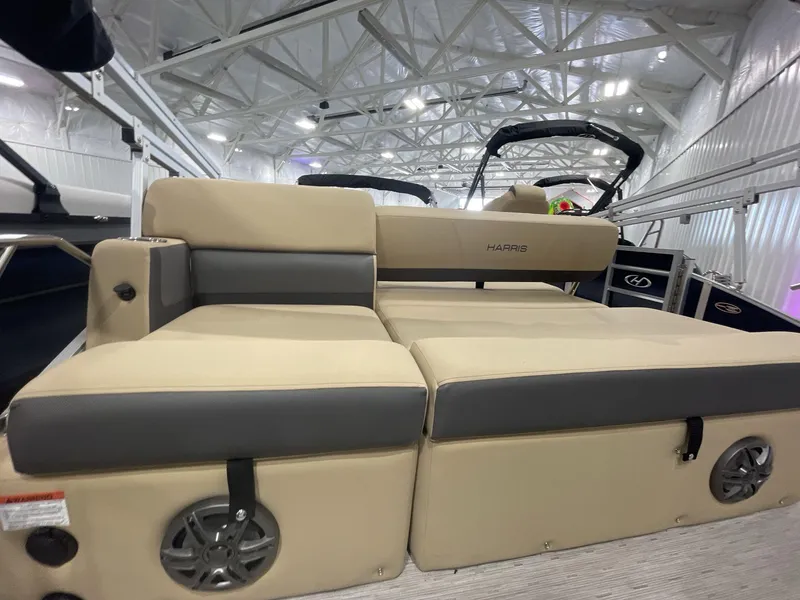 Slide: The Image of 2023 Harris Cruiser 250 boat interior with beige seating and speaker system. - 9