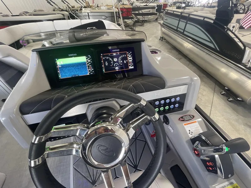 Slide: The Image of 2023 Harris Grand Mariner 250 dashboard with steering wheel and digital displays in a showroom. - 12