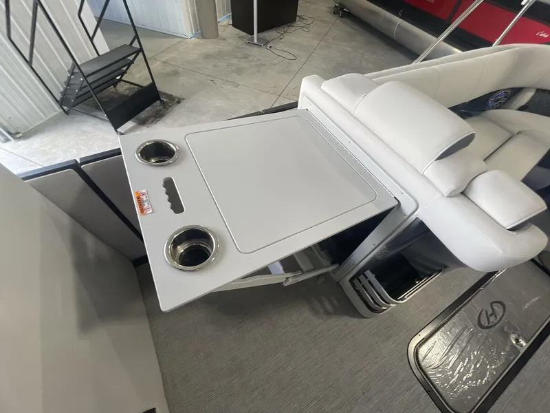 Slide: The Image of 2023 Harris Grand Mariner 250 interior with foldable table and cup holders. - 17