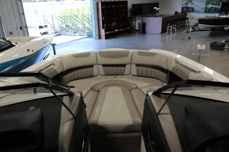 Slide: The Image of 2014 Malibu 24MXZ boat interior with plush seating in showroom. - 10