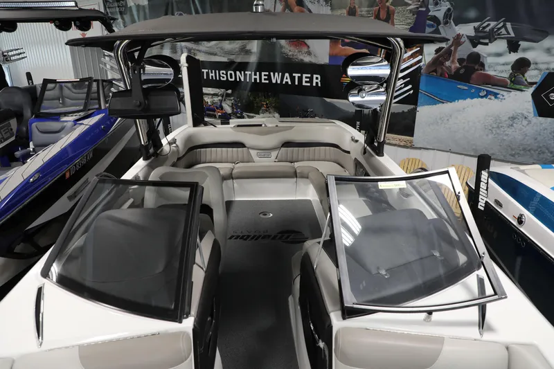 Slide: The Image of 2014 Malibu 24MXZ boat interior with seating and windshield, displayed indoors. - 12