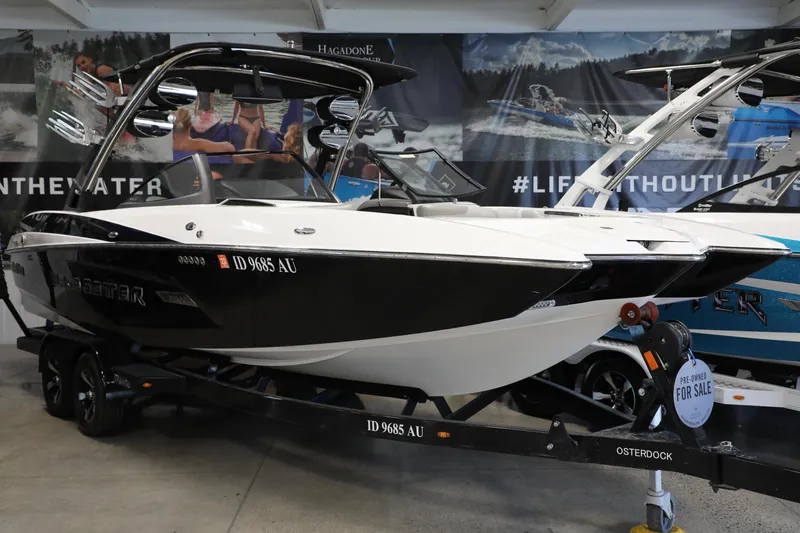 Slide: The Image of 2014 Malibu 24MXZ boat on display, black and white, for sale in showroom. - 2