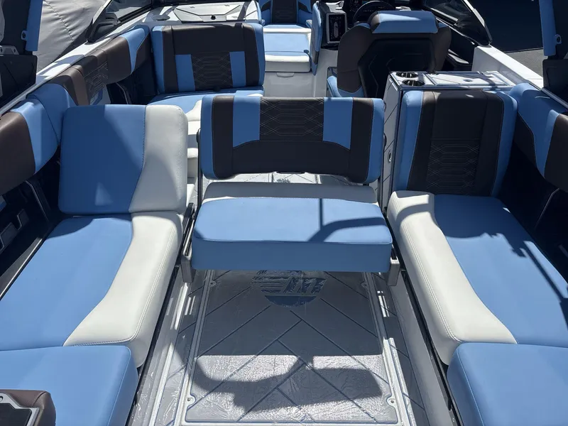 Slide: The Image of 2024 Malibu 25LSV boat interior with blue and white seating, modern design. - 16