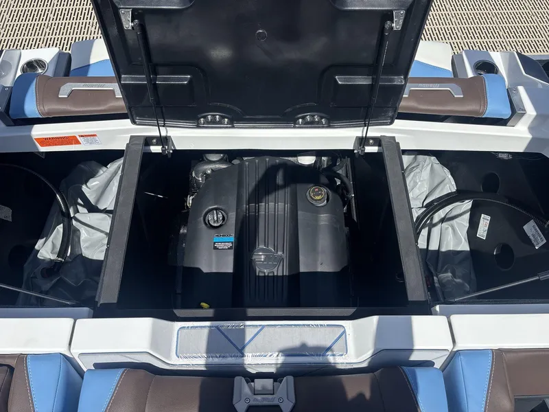 Slide: The Image of 2024 Malibu 25LSV boat engine compartment with open hatch, showcasing engine details. - 19