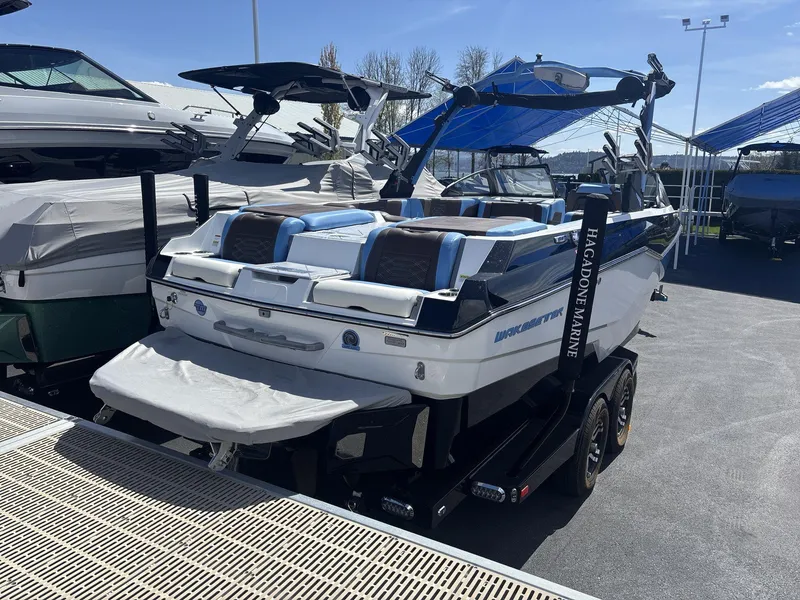 Slide: The Image of 2024 Malibu 25LSV boat on trailer at marina, featuring sleek design and modern amenities. - 4