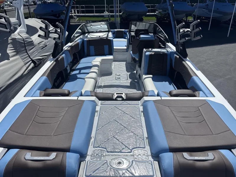 Slide: The Image of 2024 Malibu 25LSV boat interior with blue and brown seating, showcasing luxury design. - 6
