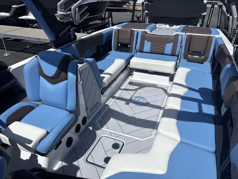 Slide: The Image of 2024 Malibu 25LSV boat interior with blue and white seating, showcasing luxury design. - 8
