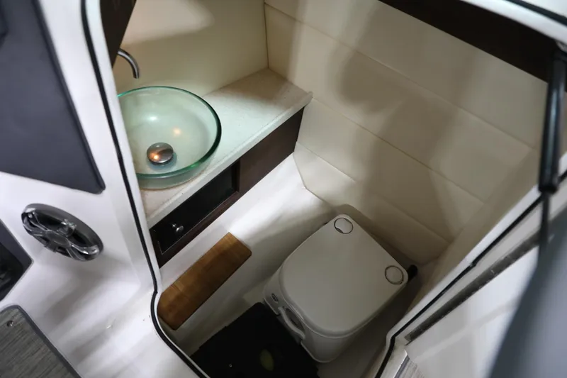 Slide: The Image of Compact bathroom in 2017 Regal 2800 Bowrider with glass sink and portable toilet. - 18