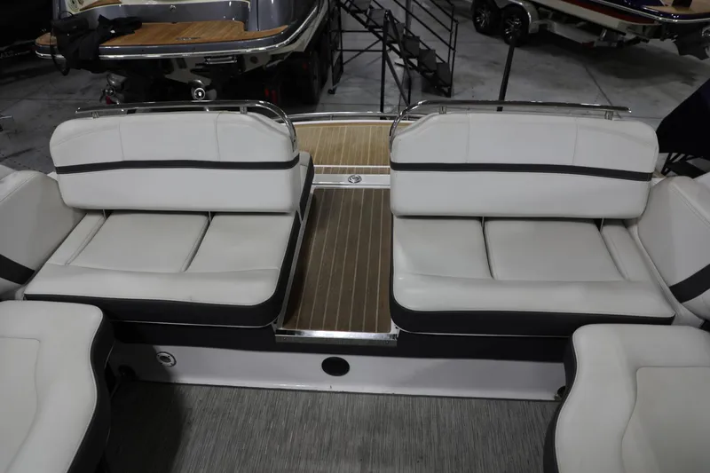 Slide: The Image of 2017 Regal 2800 Bowrider boat interior with white cushioned seating and wooden flooring. - 19