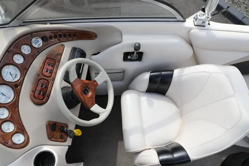 Slide: The Image of Interior of a 2000 Tigé 2100V boat with steering wheel and dashboard controls. - 8