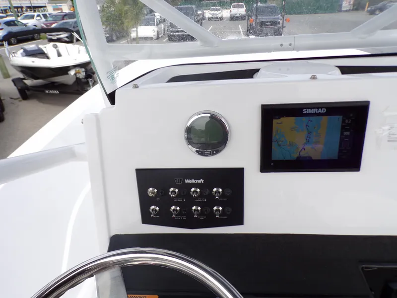 Slide: The Image of 2023 Wellcraft 202 Fisherman boat dashboard with Simrad display and control panel. - 11