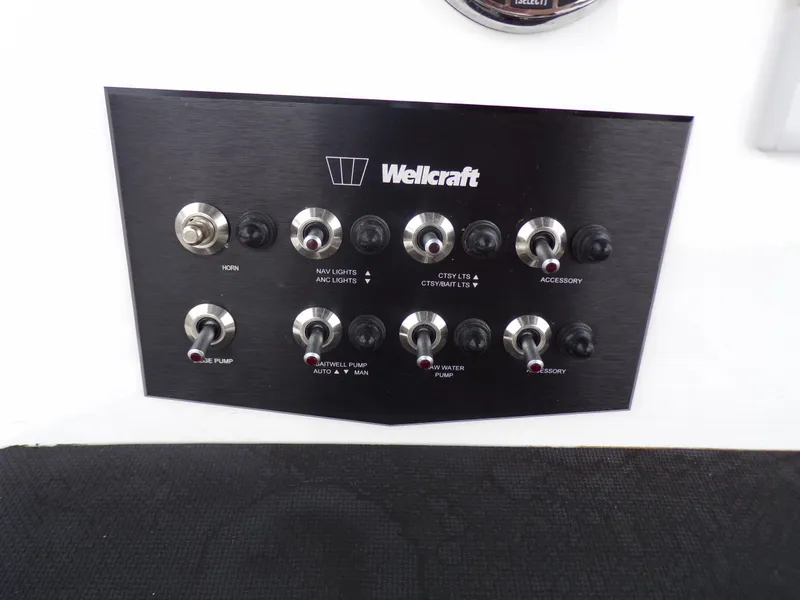Slide: The Image of Control panel of 2023 Wellcraft 202 Fisherman boat with various switches and labels. - 12