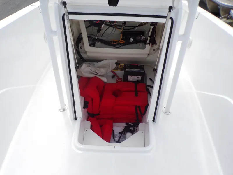 Slide: The Image of 2023 Wellcraft 202 Fisherman storage compartment with life jackets and battery. - 16