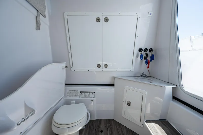 Slide: The Image of 2023 Sportsman Open 352 Center Console boat interior with toilet and storage cabinets. - 15
