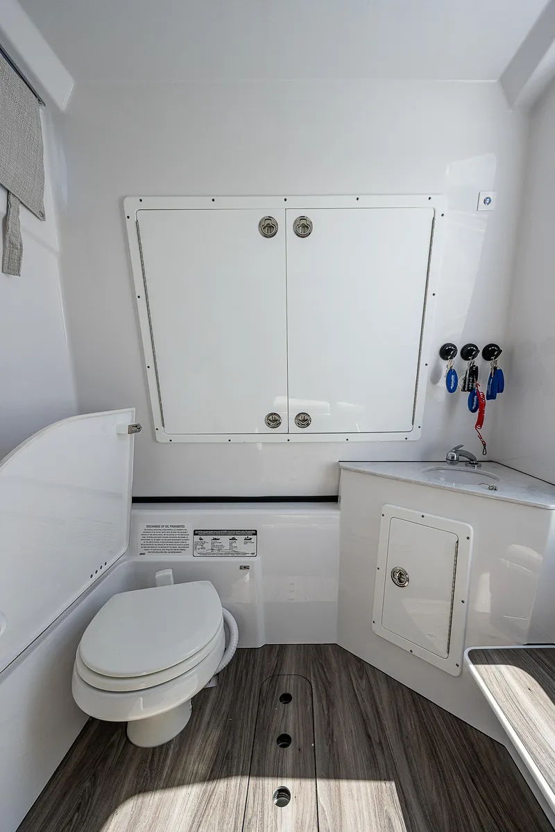 Slide: The Image of 2023 Sportsman Open 352 Center Console boat interior with toilet and storage. - 16