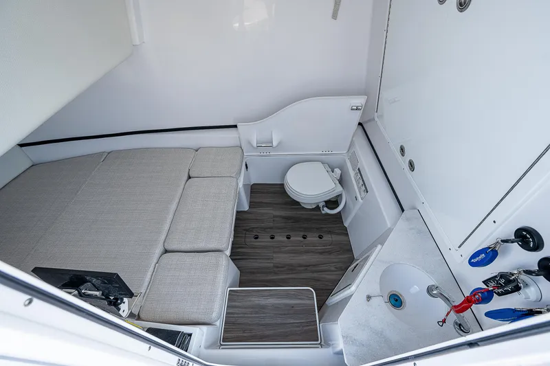 Slide: The Image of 2023 Sportsman Open 352 Center Console cabin interior with bed, toilet, and sink. - 17